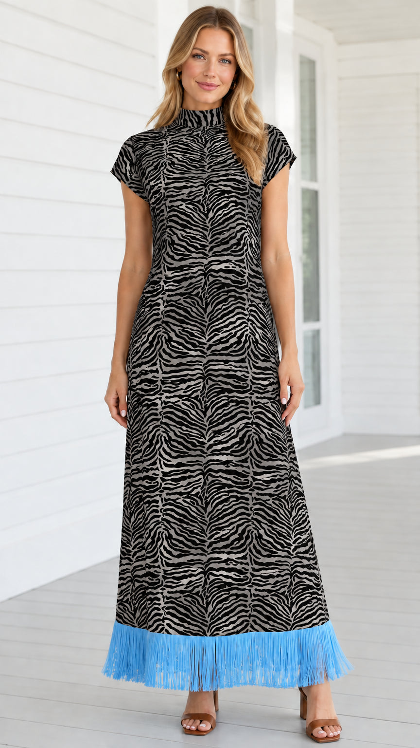 Model wearing black and white zebra print mock neck maxi dress with sky blue fringe hem