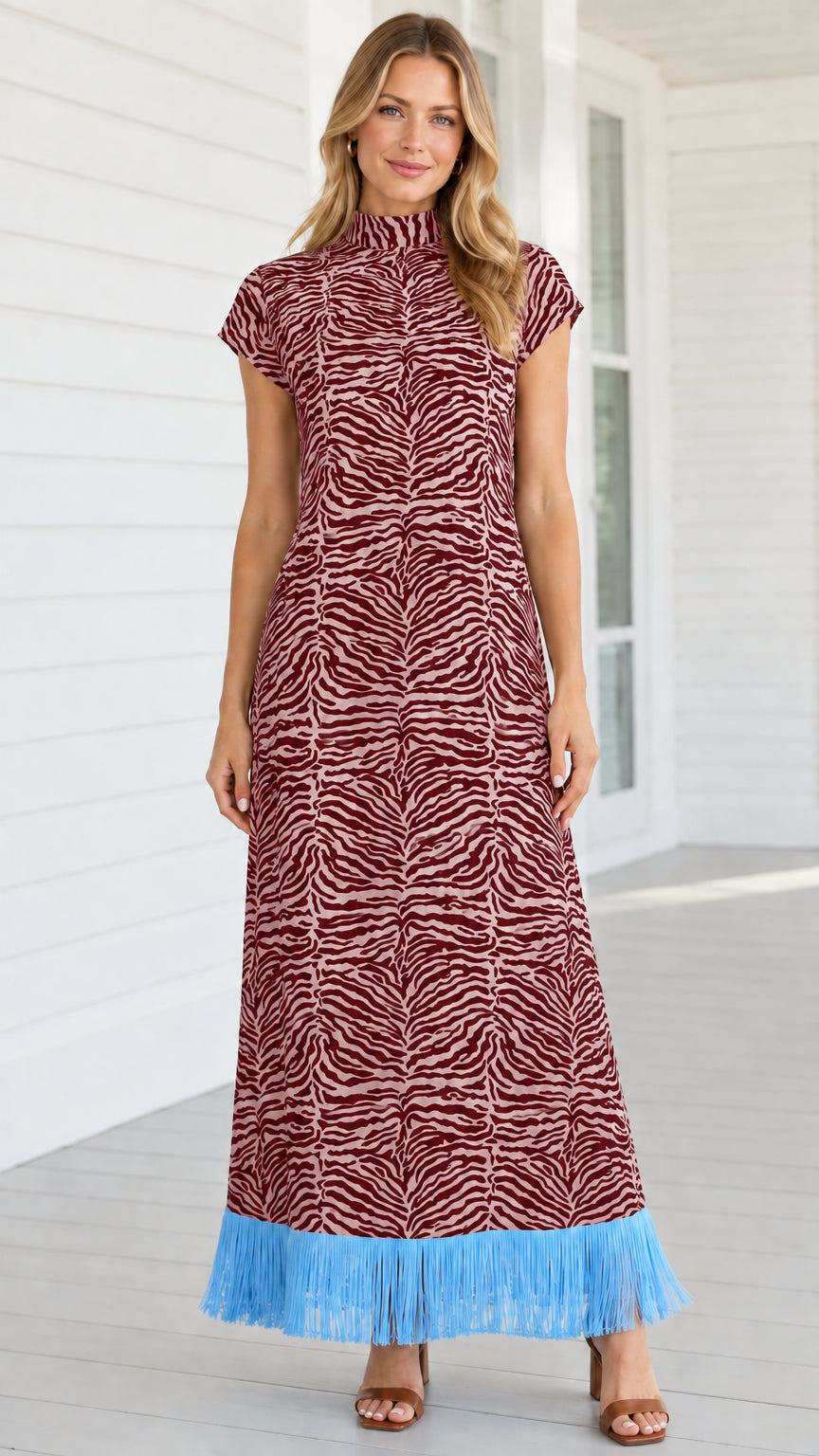 Model wearing burgundy zebra print mock neck maxi dress with sky blue fringe hem