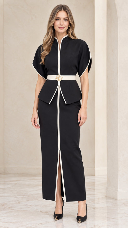 Front full-length view of model wearing black two-piece set with peplum top, white trim, and maxi skirt