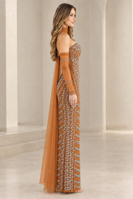 Side profile of rust orange embellished column formal gown with flowing tulle cape