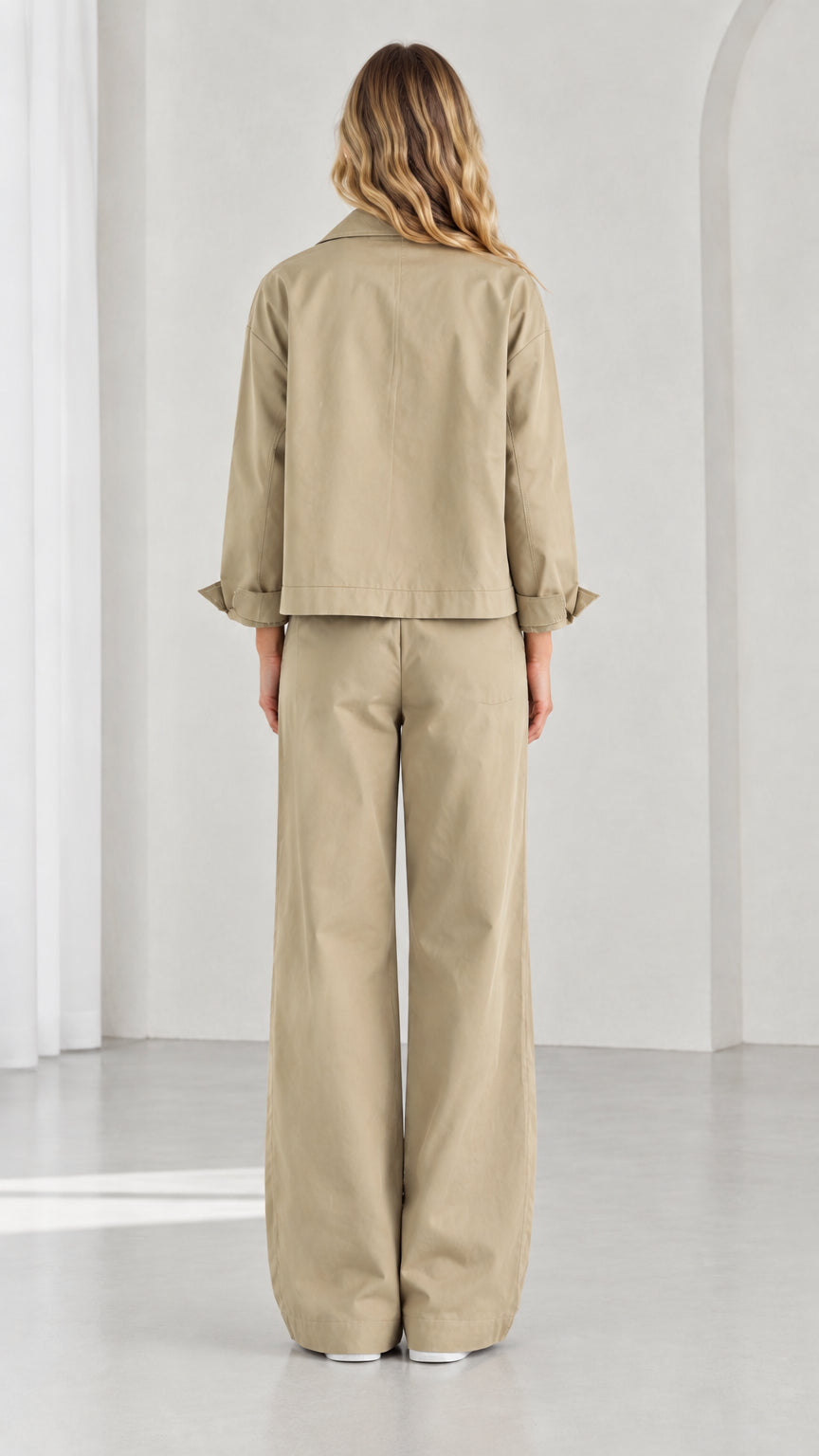 Back view of women's khaki two-piece utility jacket and wide-leg pants set