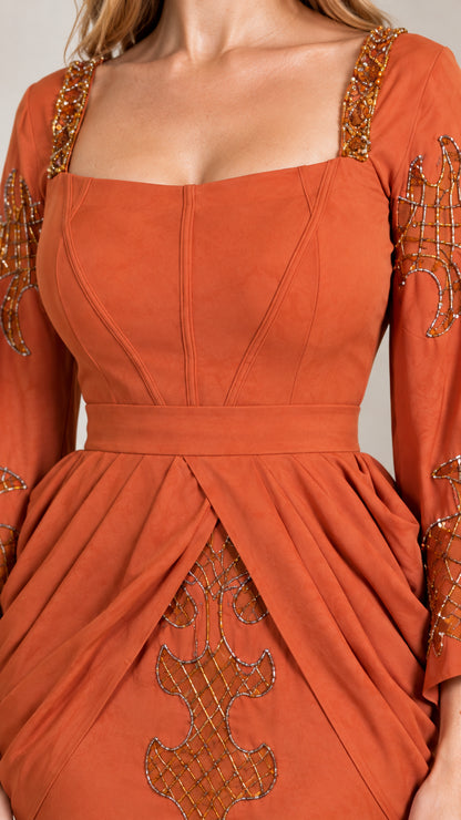 Close-up detail of bodice, square neckline, and intricate gold beadwork on rust gown