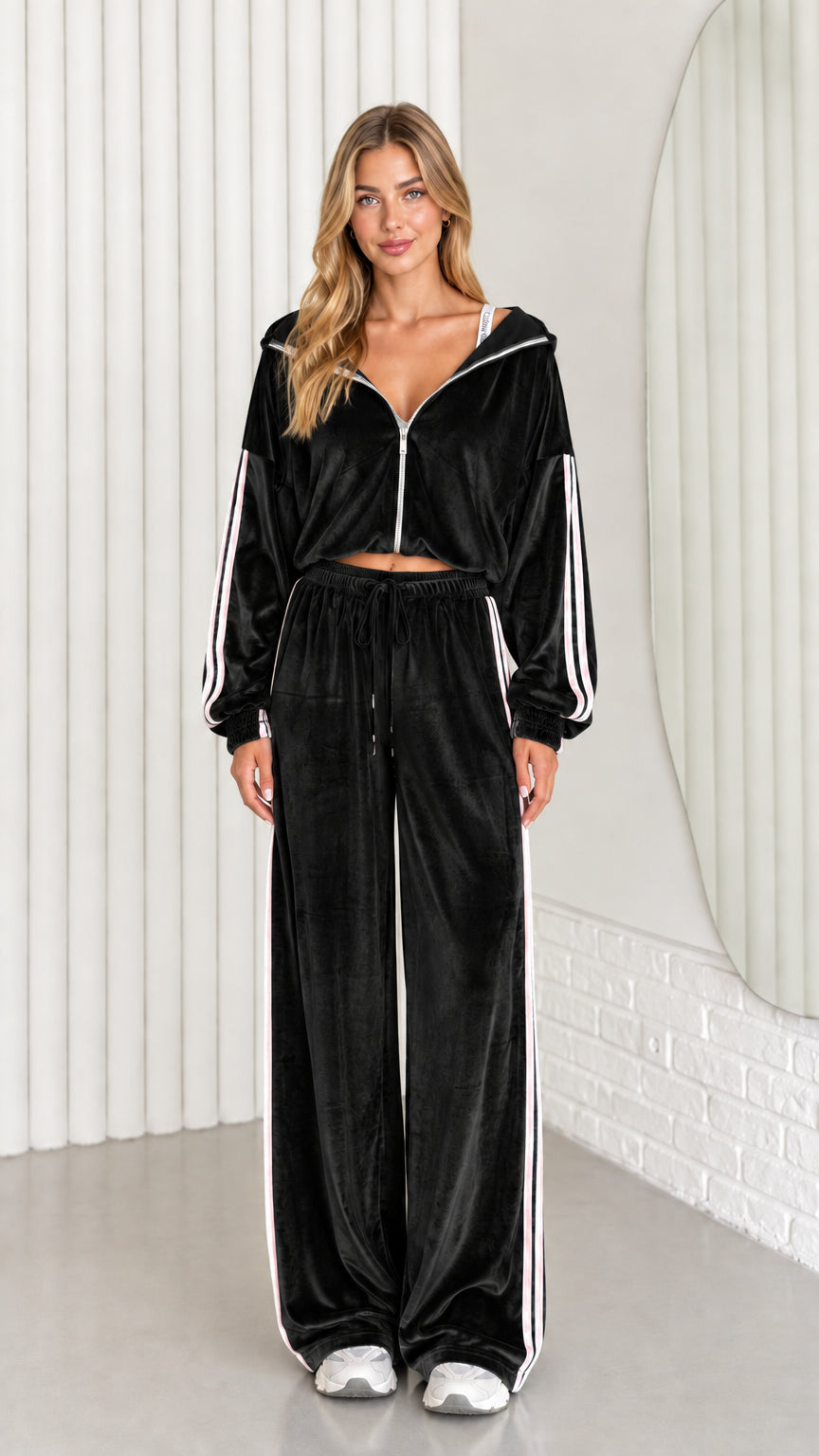 Front view of woman wearing black velour cropped zip-up hoodie and wide leg pant set