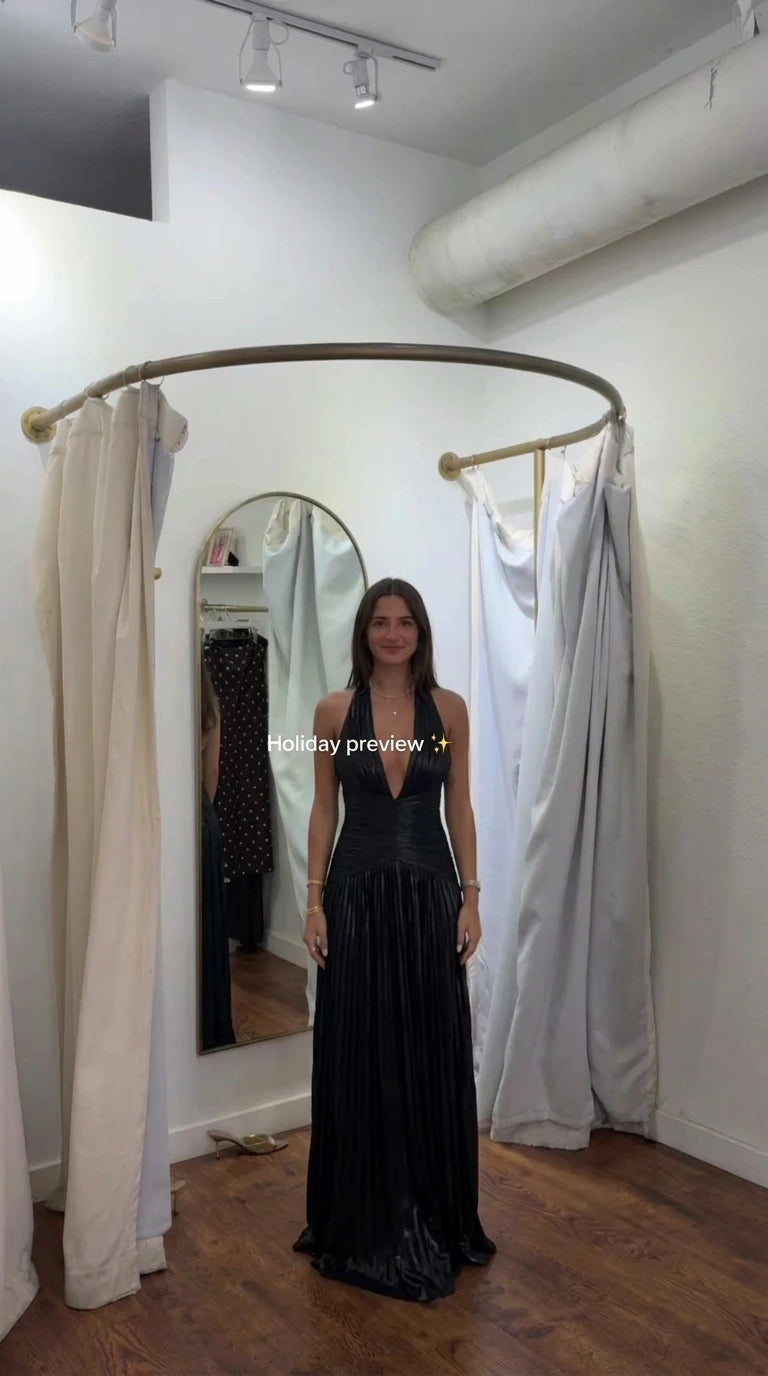 Front view of model wearing black metallic pleated halter maxi evening dress