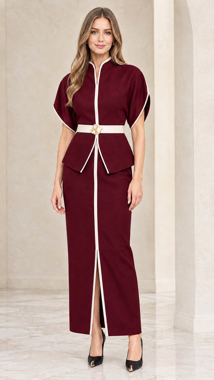 Front view of model wearing burgundy wine two-piece peplum top and maxi skirt set with white trim